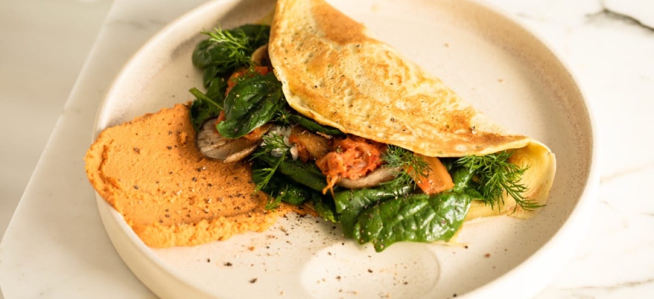 Close-up of an omelette cooking in a non-stick frying pan with butter